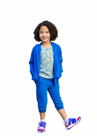 Twinflower Creations organic cotton zip-up hoodie in sonic blue worn by a smiling child with curly hair